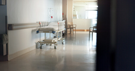 Hospital, room and interior with bed in lobby for inpatient care, recovery and health insurance. Clinic, gurney and empty space with furniture for emergency, medical service and rehabilitation