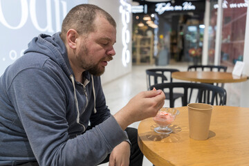 A man is sitting at a table eating ice cream