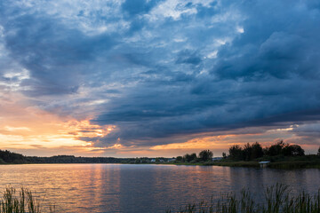 A beautiful sunset over a lake with a cloudy sky