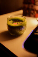 Vertical photo of a candle at night, next to a computer.