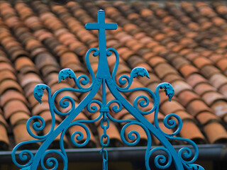 Santiago de Cuba, red tile roof and blue wrought iron cross.