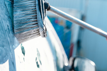 Cleaning  Car With  Brush at Car Wash on Sunny Day