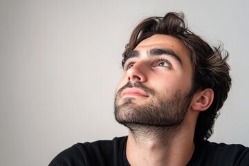 Fototapeta premium Man looking up thoughtfully, clean background.