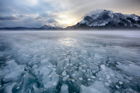 Canada, Alberta, Abraham Lake. Winter sunrise over lake and Mount Michener.