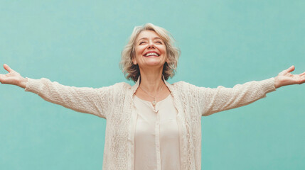 Mature Caucasian woman with open arms isolated on blue background , studio shot of a beautiful white European old retired lady with happy smiling face welcome with open arms on teal color backdrop