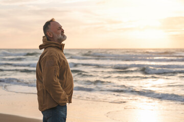 Man Enjoying Peaceful Moment by  Shoreline at Sunset