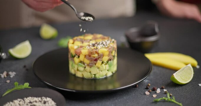 Traditional tuna and mango tartare on black ceramic plate