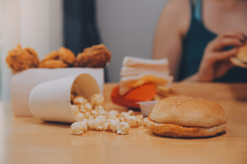 fast food, people and unhealthy eating concept - close up of woman hands holding hamburger or cheeseburger