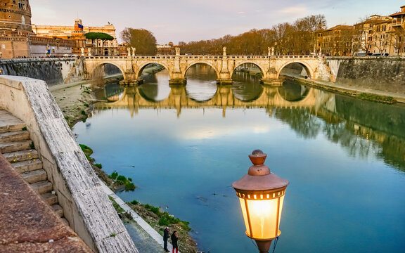Street lamp. St. Angelo Bridge, Tiber River reflection, Rome, Italy. Bridge first built by Emperor Hadrian in 134 AD.