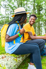 African friends sitting enjoying nature during hiking in the forest