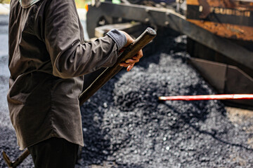 man working with a hammer. truck in the sand