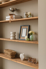 Shelves with blank photo frame mock up, vases and assorted ornaments. © Nina