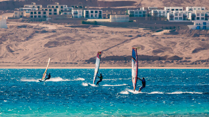 three surfers compete in the Red Sea in the lagoon in Egypt Dahab