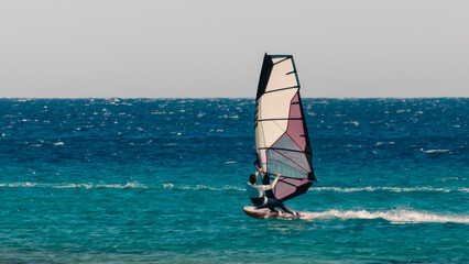 young surfer girl rides a sail in the Red Sea in Egypt Dahab