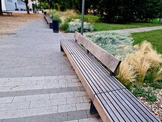 edge of the elevated terrace overlooking the park is a concrete long flowerpot with wood paneling...