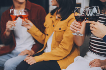 Happy friends making a toast with beer before eating pizza in a shared apartment.
