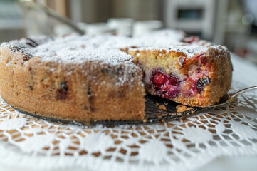 Fresh and homemade plum cake or plum pie with powdered sugar. Closeup