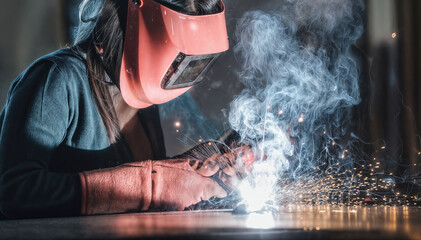 Fototapeta premium Welder working with sparks and mask in industrial factory setting