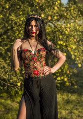 Woman with long black hair in Ethnic embroidered corset, flowers details. Concept of beauty women, style