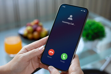 female hands holding phone with incoming call screen in cafe