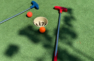 Golf stick and ball on green grass close up.