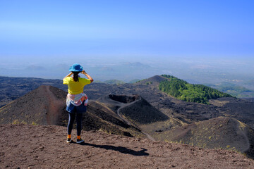 Joven chica con camisa amarilla haciendo senderismo en el Monte Etna: el Parque y el Valle del...