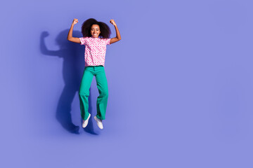 Full size photo of pretty young girl jump flexing muscles wear trendy pink outfit isolated on purple color background