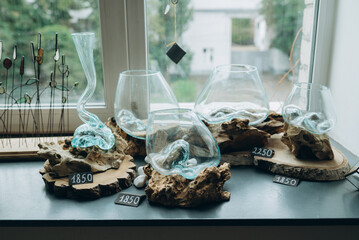 decorative glass vases mounted on natural wooden bases. These vases of different shapes and sizes...