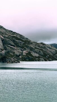 Video Schwenk auf einen sch&ouml;nen Gletscher in Norwegen, gute Stimmung. Folgefonna, Video im Hochformat. Im Vordergrund See, Fjord