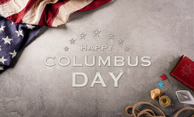 Happy Columbus Day concept. Vintage American flag, compass, paper boat, rope on dark stone...