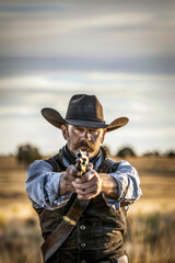 A rugged cowboy aims his pistol intently, standing against a vast, desolate desert landscape, embodying the essence of the wild west and evoking themes of solitude and determination.