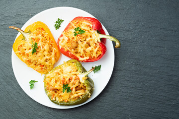 Baked stuffed pepper ( paprika ) with rice , carrot and meat . Top view on rustic background