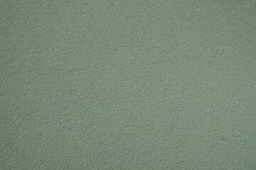 Closeup of reseda green wall with coarse roughcast finish