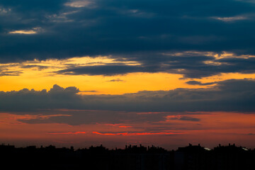Obraz premium Sun Hid Behind the Silhouettes of Buildings at Sunset