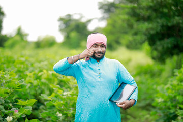 happy young Indian farmer using smart phone