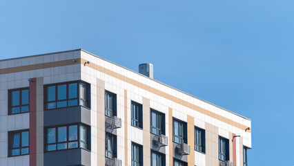 Obraz premium Moscow, March 19 2024, A large building with many windows and a clear blue sky in the background. The building is tall and has a modern look