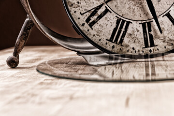 Broken old analog clock with glass and metal frame on wooden table, broken structure