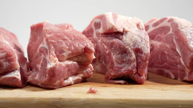 Pork meat on a cutting board rotates on a white background. Raw pork meat on white.