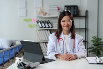 Young female doctor sitting at the desk preparing to receive patients in the medical clinic. Medicine. Data recording. Medical personnel at a clinic or hospital.