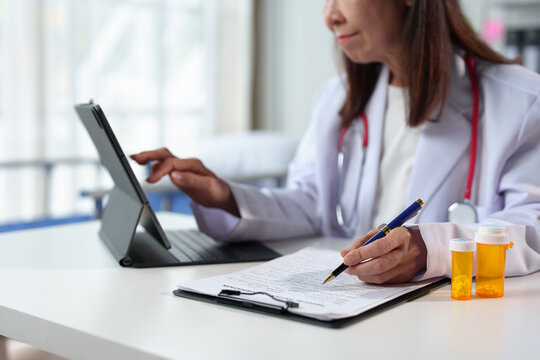Young female doctor sitting at the desk preparing to receive patients in the medical clinic. Medicine. Data recording. Medical personnel at a clinic or hospital.
