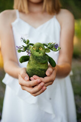 girl holding a handmade toy in her hands