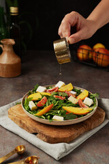 Peach and goat cheese salad with rucolla. salad on a dark background.