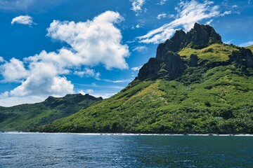 Wonderful sunny day on the Yasawa islands in Fiji. Small clouds over lush green hills. Beautiful, paradise-like, tropical small islands close to the main islands of Fiji. 