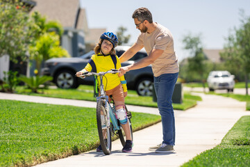 Obraz premium Fathers day. Boy learning to ride a bicycle with his father in park. Father teaching his son cycling on bike. Father learn little son to ride a bicycle. Father support child. Fathers day background.