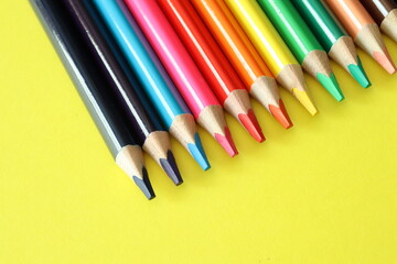 Fototapeta premium a group of multi-colored colorful large pencils on a yellow background