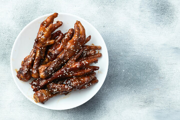 Caramelized korean or Chinese chicken foots ( paws ) with sesame . Top view