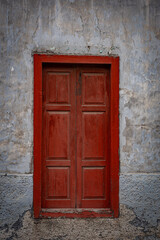 old weathered building with red door