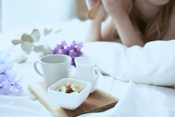 爽やかな朝に寝室のベッドでくつろぐ女性