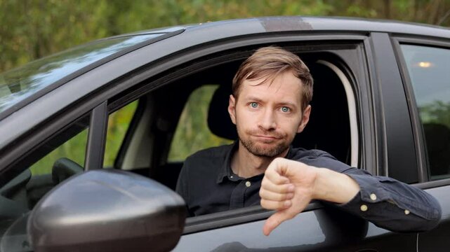 Sad driver showing thumbs down in car. Bad customer service by repair shop.