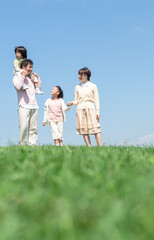 芝生を歩く家族